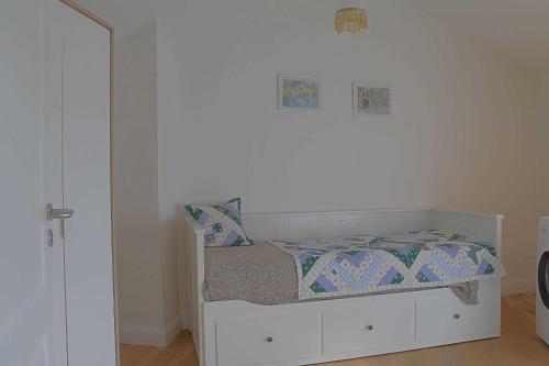 a small white bedroom with a bed and a mirror at Strandlaeufer NS6 Wremen in Wremen