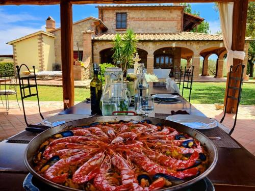 una mesa con una sartén de comida encima en Agriturismo Il Raduno - Max Lelli, en Marsiliana