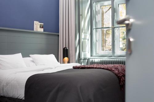 a bedroom with a bed with a blue wall and a window at Saint SHERMIN bed breakfast & champagne in Vienna