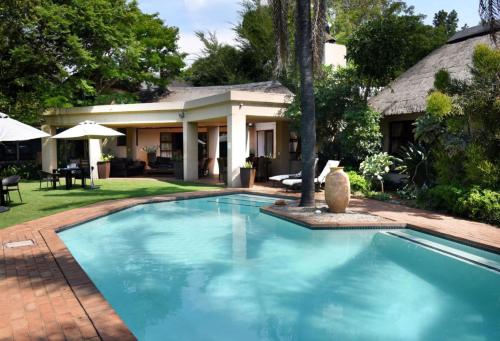 una piscina frente a una casa en Lourie Lodge, en Johannesburgo