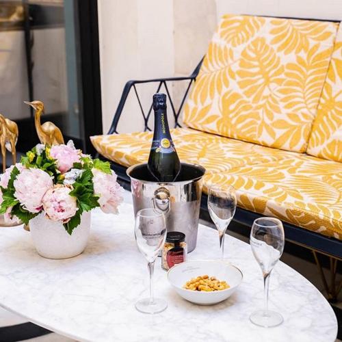 - une bouteille de vin assise sur une table avec des verres à vin dans l'établissement Hôtel George Washington, à Paris