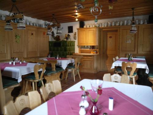 a dining room with tables and chairs with pink table cloth at Gästehaus Taubensee in Oberwössen