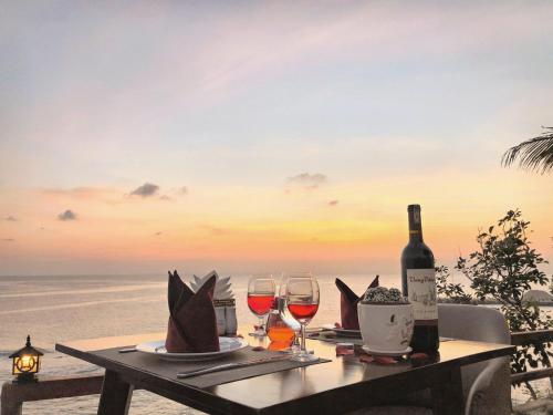 einen Tisch mit zwei Gläsern Wein am Strand in der Unterkunft Ly Son Pearl Island Hotel & Resort in Ly Son