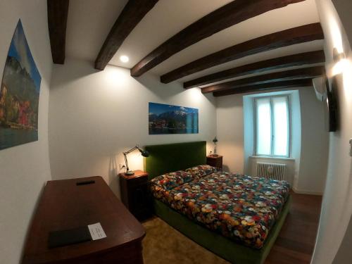 a bedroom with a bed and a table and a window at La Casa sul Lago Lecco 2 in Lecco