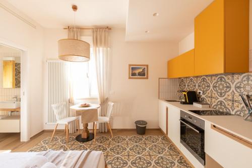 a kitchen with yellow cabinets and a table with chairs at Dimora Labbate in Polignano a Mare