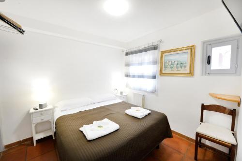 ein kleines Schlafzimmer mit einem Bett und einem Stuhl in der Unterkunft Perugia Apartments in Perugia