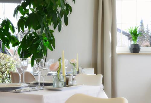 un tavolo bianco con occhiali e piante sopra di Hotel Sonnenhof - Superior a Zwiesel
