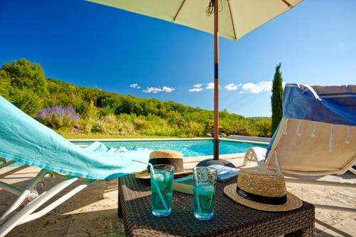 - une table avec deux verres à côté de la piscine dans l'établissement La Bruyle - Chambre d'hôtes de charme, à Saint-Michel-de-Bannières
