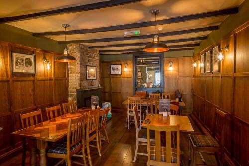 a dining room with wooden tables and chairs at The Howard Arms in Brampton