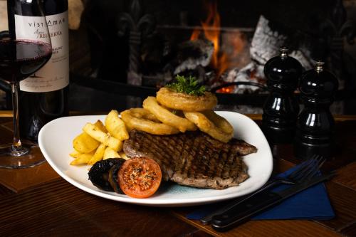 a plate of steak and french fries and a bottle of wine at The Howard Arms in Brampton