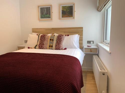 a bedroom with a large bed and two windows at Griff Cottage, Skinningrove in Skinningrove