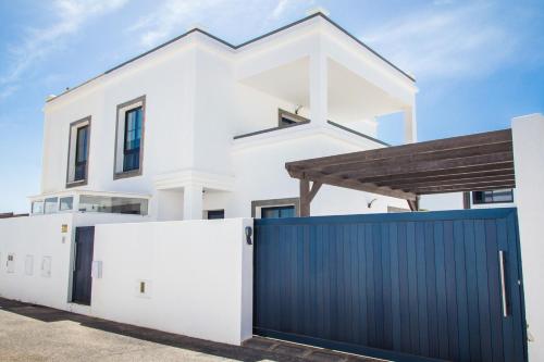 una casa bianca con un cancello blu di Villa Garoed a Playa Blanca