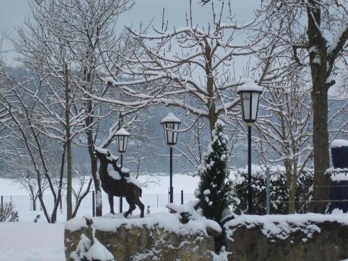 a statue of a deer in a park in the snow at Hirschenwirt in Eichstätt