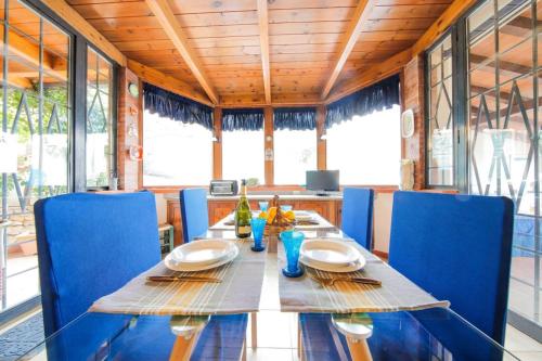 uma sala de jantar com uma mesa e cadeiras azuis em Villa Rosa Bianca em Palermo
