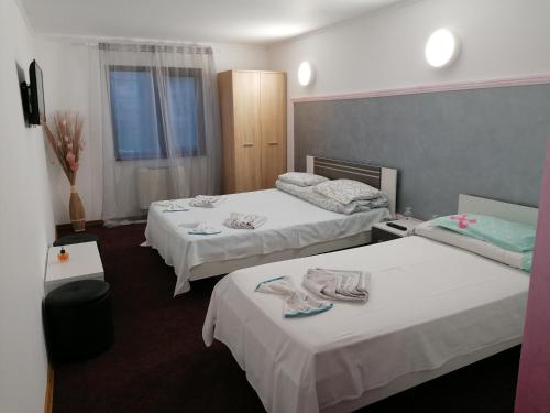 a hotel room with two beds with towels on them at Hotel Hobby in Hunedoara