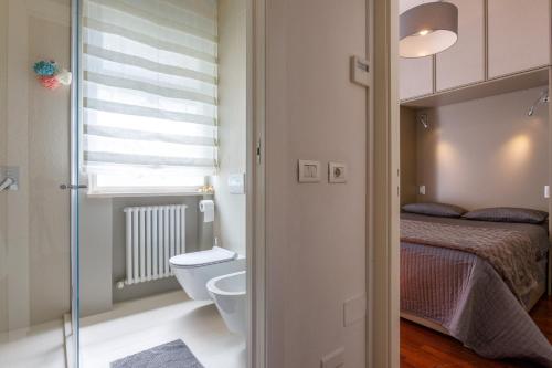 a bathroom with a toilet and a bed and a window at VILLA CORONA 8, Emma Villas in Cattolica
