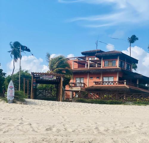 a house on the beach next to the sand at Beach front apartment in Dream Village Cumbuco, Ceara in Cumbuco