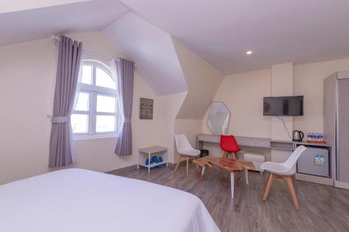 una camera con letto, sedie e scrivania di Tường Vy 2 Hotel a Da Lat
