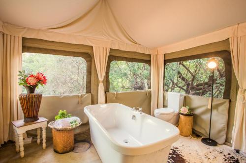 a large bathroom with a tub and a toilet at Zwartkloof Adventures Tented Camp in Bela-Bela