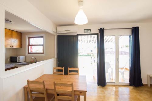 a kitchen and dining room with a table and chairs at Nuvolet Apartaments in Cala en Blanes