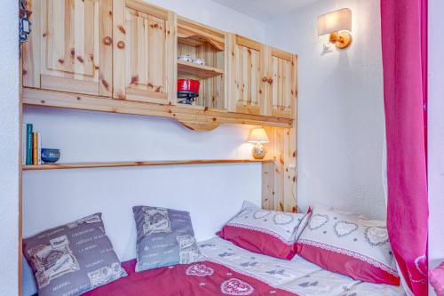a bedroom with a bed and a wooden cabinet at Le Flocon in Flumet