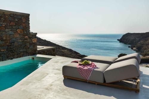 a couch sitting on a patio overlooking the ocean at Phos Villas Tinos in Agios Romanos