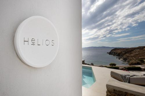 a sign on the side of a building with a view of the ocean at Phos Villas Tinos in Agios Romanos