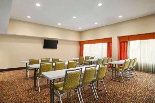 a conference room with tables and chairs and a flat screen tv at La Quinta Inn & Suites by Wyndham Richmond-Midlothian in Midlothian