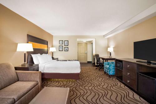 a hotel room with a bed and a flat screen tv at La Quinta Inn & Suites by Wyndham Richmond-Midlothian in Midlothian