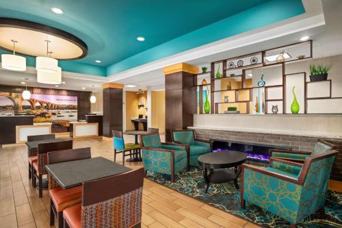 a restaurant with tables and chairs and a bar at La Quinta Inn & Suites by Wyndham Richmond-Midlothian in Midlothian