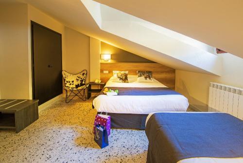 a hotel room with two beds and a chair at Hotel Austria by Pierre & Vacances in Soldeu