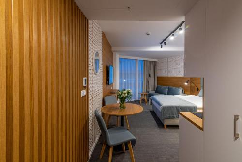Seaside Apartaments Deluxe 627 في كولوبرزيغ: غرفة فندق بسرير وطاولة وغرفة نوم