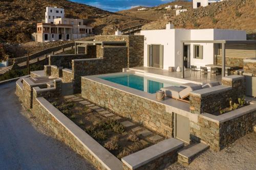 a villa with a swimming pool and a house at Phos Villas Tinos in Agios Romanos