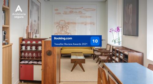 a restaurant with a waiting room with tables and chairs at El Museo Suites in Málaga