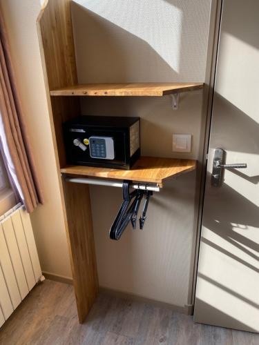 a microwave on a shelf next to a door at Angleterre Hotel in Paris