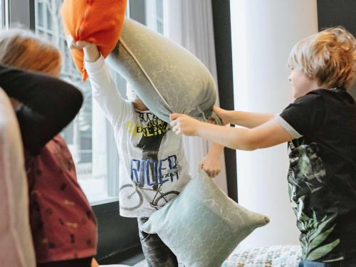 two children playing with pillows in a room at ibis Styles Basel City in Basel