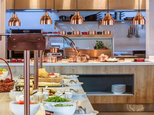 a buffet line with plates of food in a kitchen at Tarcin Forest Resort & Spa Sarajevo - MGallery Collection in Tarčin