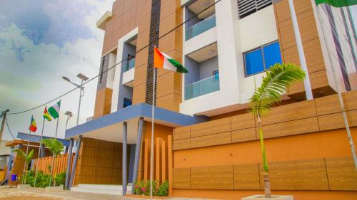 a building with flags in front of it at Hotel La Casa Cielo in Cotonou