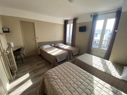 a hotel room with two beds and a desk at Angleterre Hotel in Paris