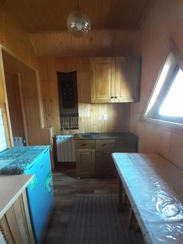 a kitchen with wooden cabinets and a table in it at Willa Anna in Kościelisko