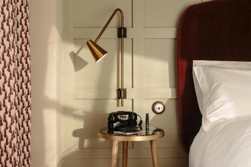 a hotel room with a bed and a lamp at The Hoxton, Southwark in London