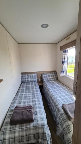 Säng eller sängar i ett rum på Luxury 2019 8 berth Caravan with Hot Tub @ Tattershall Lakes
