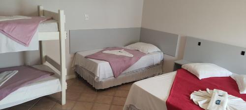 a small room with two bunk beds in it at Hotel Pousada Ilha do Mar Bombinhas in Bombinhas