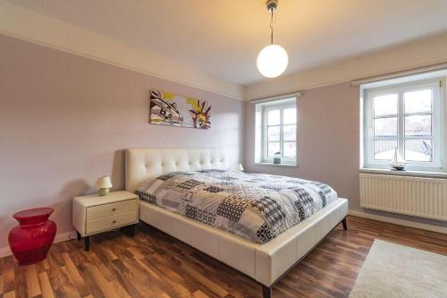 sypialnia z białym łóżkiem i 2 oknami w obiekcie Haus-Godewind-Typ-3 w mieście Binz