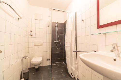 W łazience znajduje się toaleta, umywalka i prysznic. w obiekcie Haus-Godewind-Typ-3 w mieście Binz