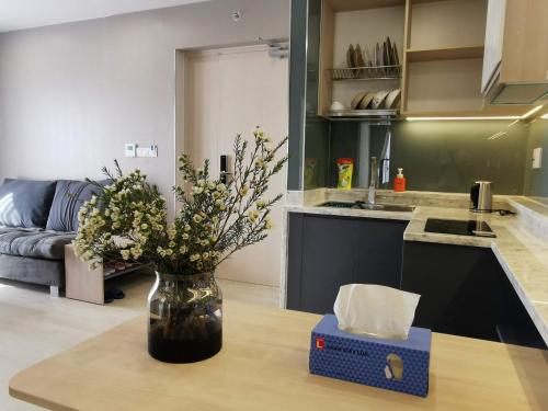 a vase of flowers sitting on a table in a kitchen at Gold Coast Luxury Apartment Nha Trang in Nha Trang