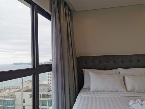 a bedroom with a bed and a large window at Gold Coast Luxury Apartment Nha Trang in Nha Trang
