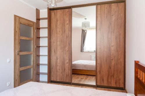 a sliding glass door in a bedroom with a bed at Fantastic By The Sea Apartment Set Up With Love in Gdańsk