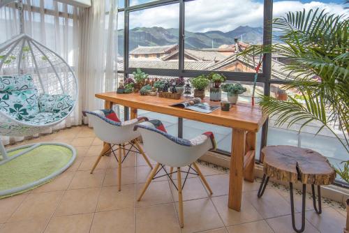 a room with a table and chairs and a large window at Baisha Flamingo Hotel in Lijiang