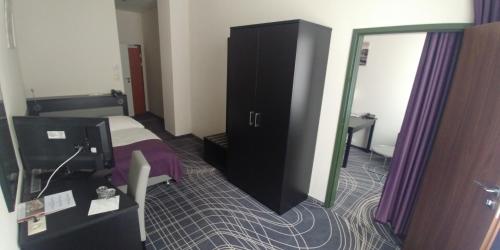 a hotel room with a bed and a mirror at Sky Business Hotel in Legnica